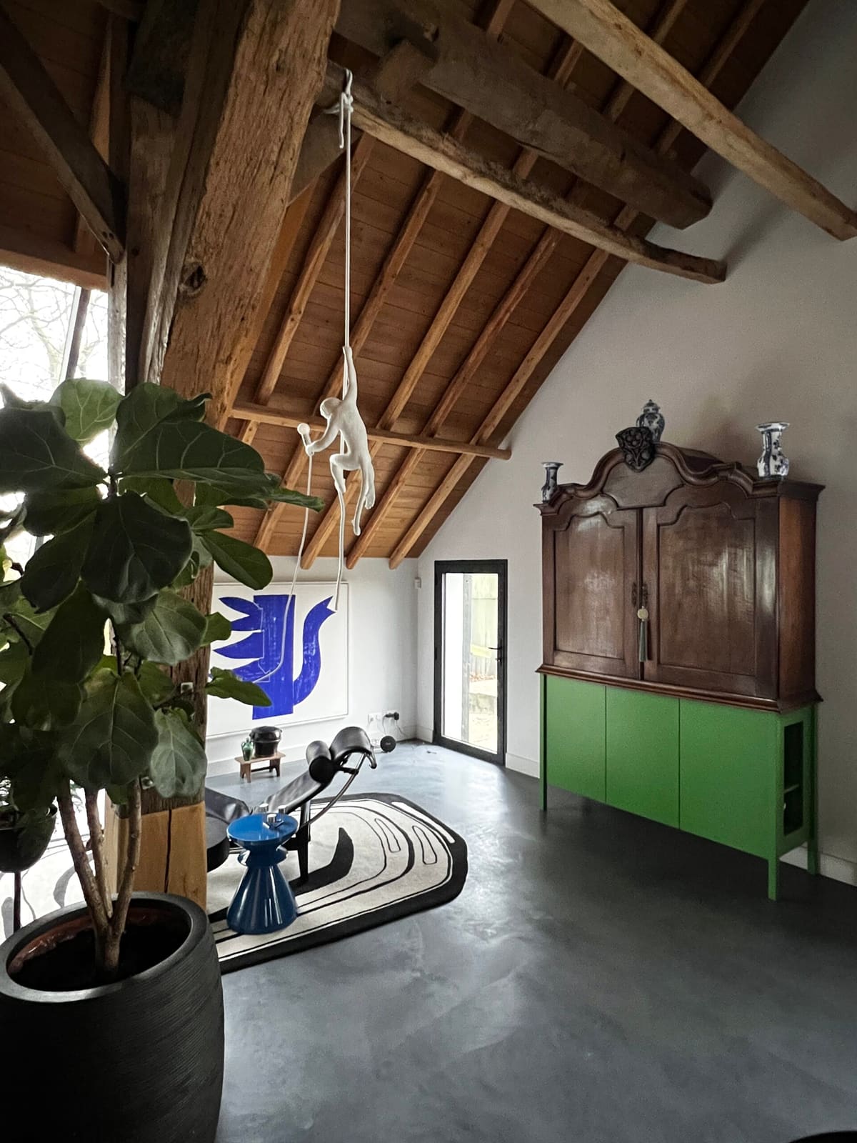 Interieurontwerp en interieurstyling met houten balken, groene kast en kunst